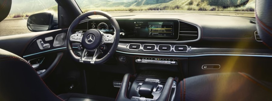 Vista a parte delantera de híbridos enchufables con tablero, pantalla inteligente y manubrio con paisaje de fondo