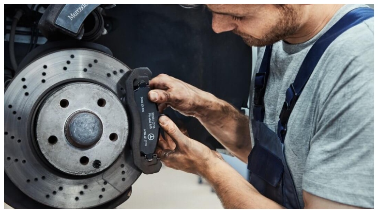 Tecnico especializado de talleres Mercedes Benz revisando los frenos de un vehiculo