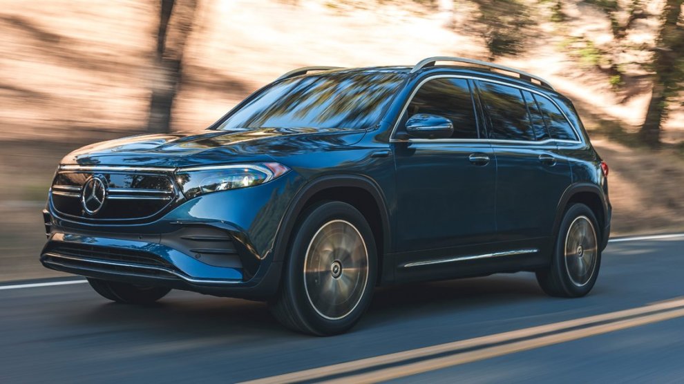 <p>Camioneta Mercedes Benz EQB familiar color azul siendo conducida por autopista con fondo de árboles.</p>