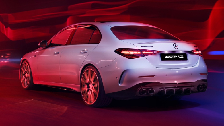 Vista trasera de Mercedes-AMG Clase C blanco plateado siendo conducido a alta velocidad con ondas color rojo y azul.