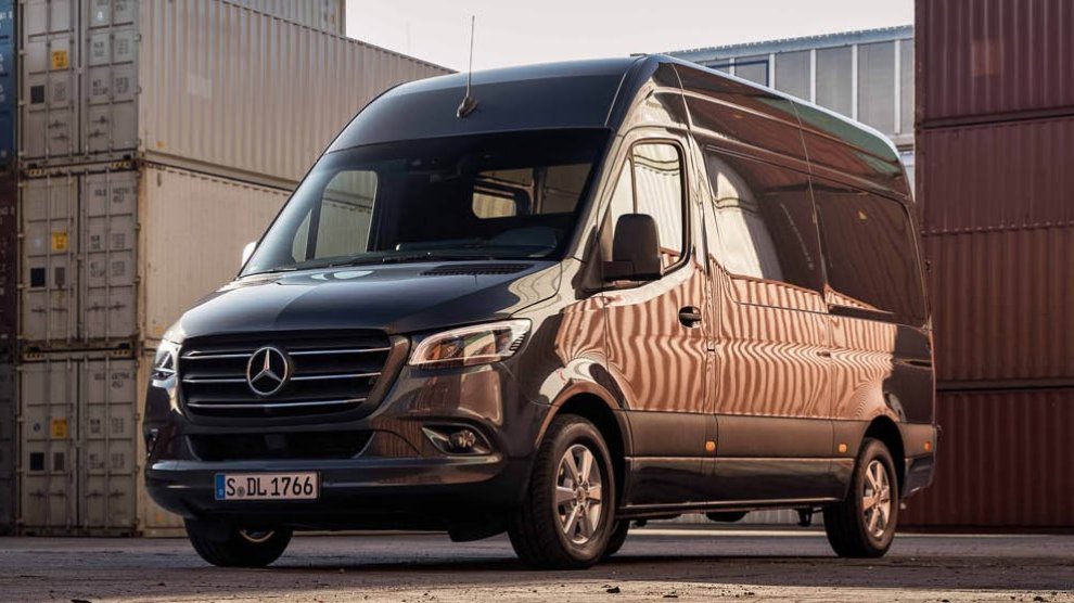 <p>Van de lujo Mercedes-Benz Sprinter de pasajeros color negra estacionada en zona de carga con contenedores alrededor.</p>