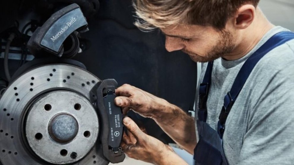 <p>Persona instalando pastillas de  frenos en un auto Mercedes-Benz.</p>